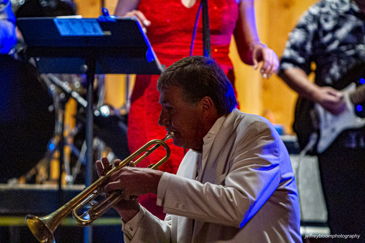 A man playing the trumpet while dancing around